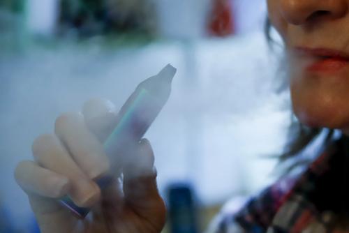 FILE: A woman uses her vaping device in Harmony, Pa, Oct. 4, 2019.