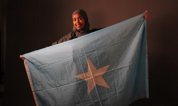 (Lauren Baese | Special to The Tribune) Anud Hashi, a senior at Highland High School in Salt Lake City, poses with the Somalia flag. She is concerned about gun violence in her Somali community and joined a prevention organization.