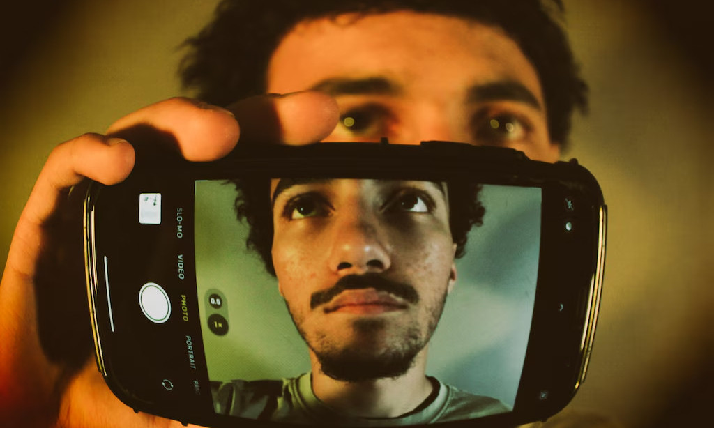 (Red Gunn | Special to The Tribune) Ali Jadallah, a senior at Highland High School in Salt Lake City, poses with his iPhone. He says instant connection to events around the world motivates him to get involved.
