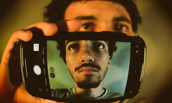 (Red Gunn | Special to The Tribune) Ali Jadallah, a senior at Highland High School in Salt Lake City, poses with his iPhone. He says instant connection to events around the world motivates him to get involved.